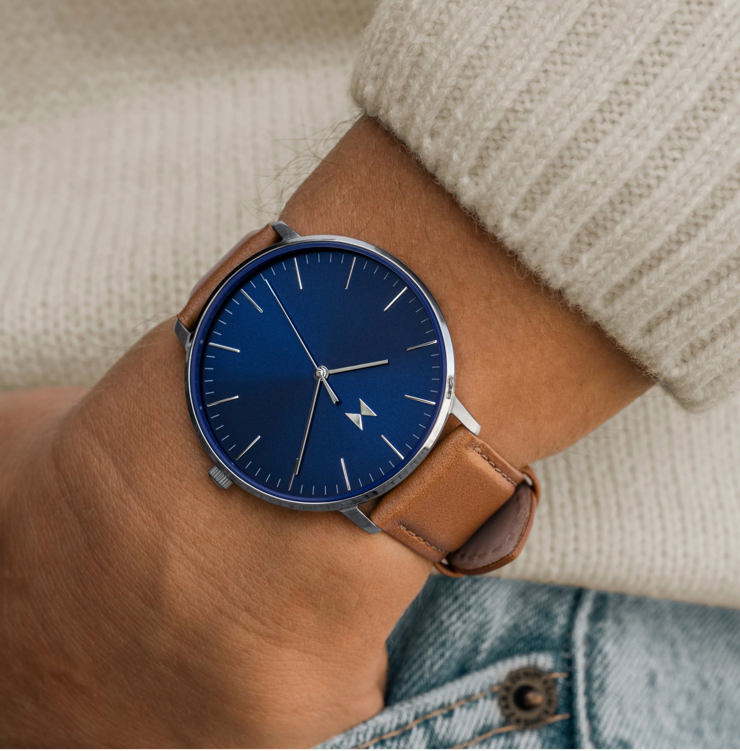 MVMT Legacy Slim watch with tan strap and blue face on wrist